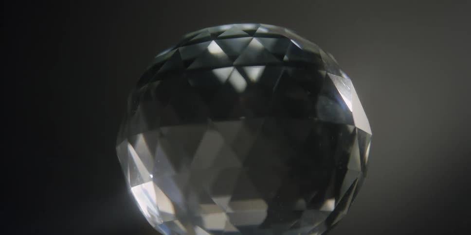 There is a disco ball moving slowly inside of a room