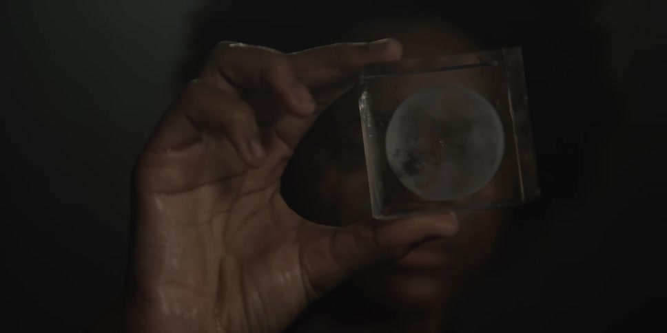 A woman is holding a clear cube