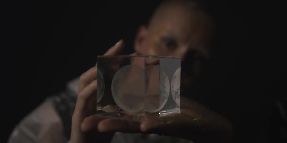 A woman is examining a cube