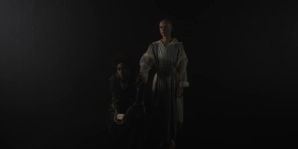 Two females are standing by each other during the night