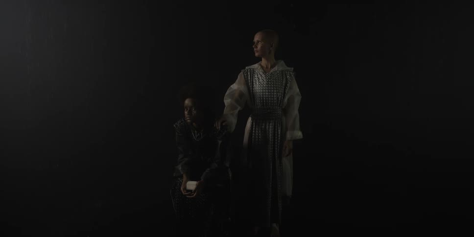 Two people are standing by each other in a dark room