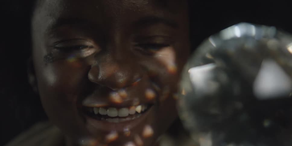 Teenage girl looks at crystal ball laughing