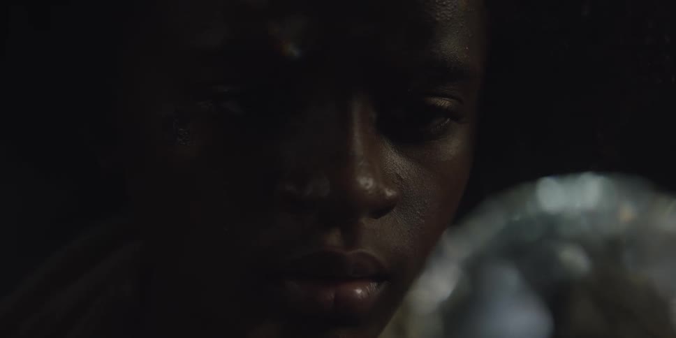 Teenage girl stares at crystal ball in dark room