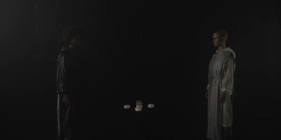 Two people are standing by a table and staring at each other