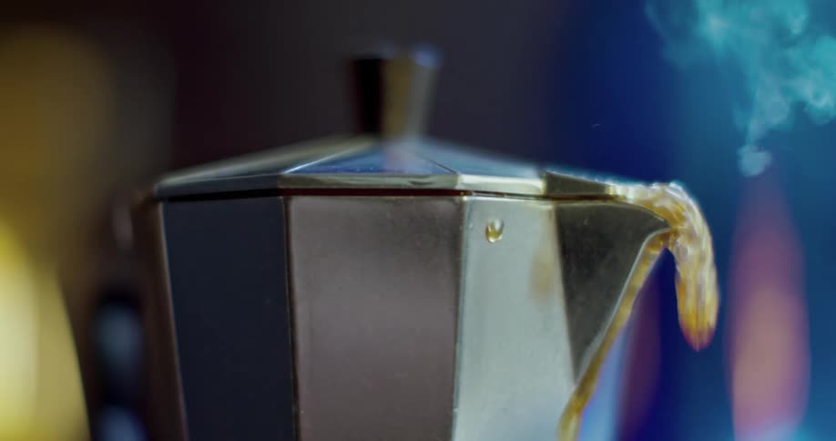 Coffee and steam pours and overflows out of a percolator spout