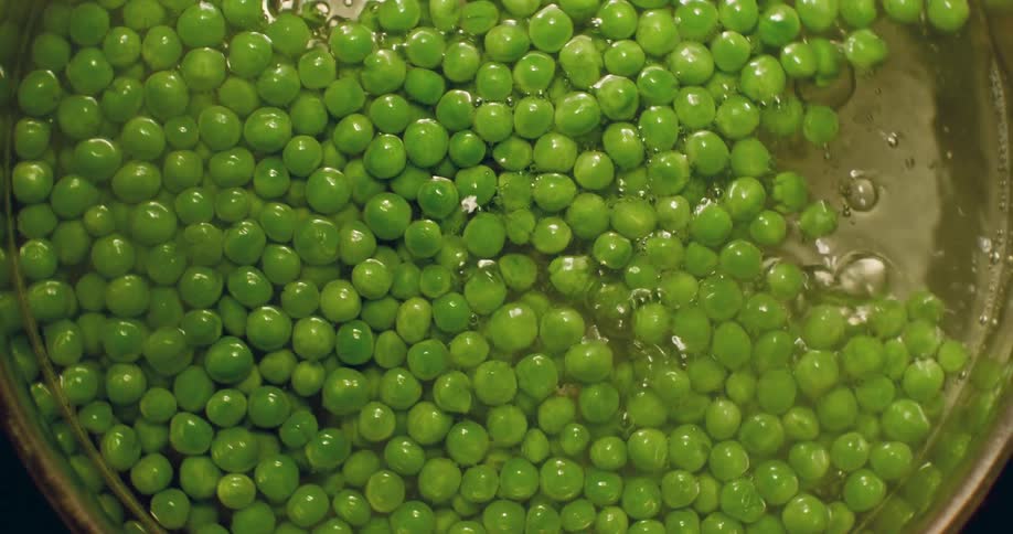 Top shot of peas boiling in a pan