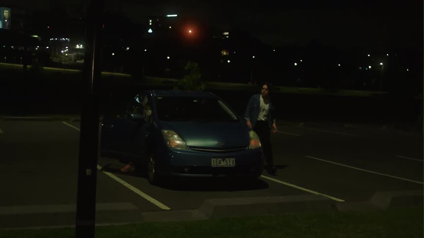 A man parks his vehicle and quickly walks away while a woman tries to catch up