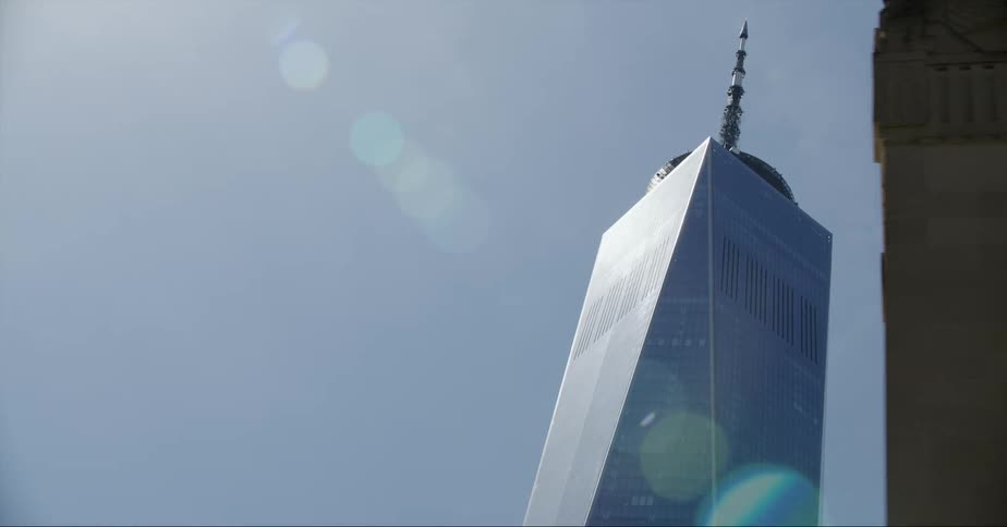 A tall skyscraper towering overhead on a sunny clear day