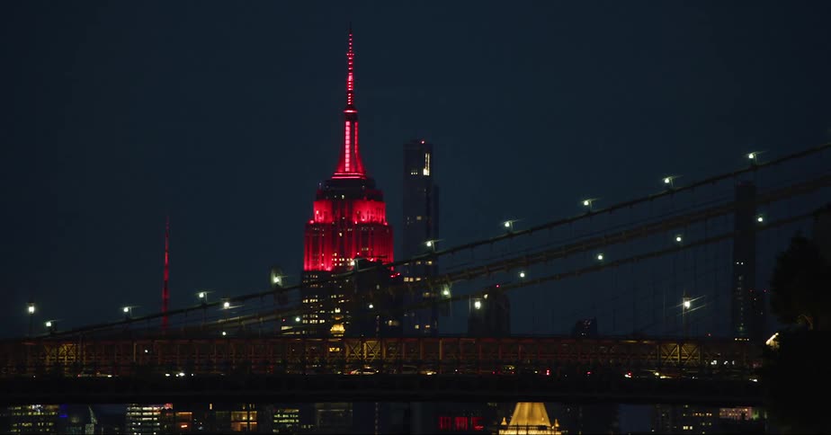 A tall building with a prominent spire stands tall above a city skyline