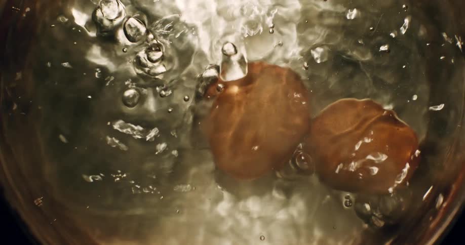 Two eggs are boiling in a pot of water