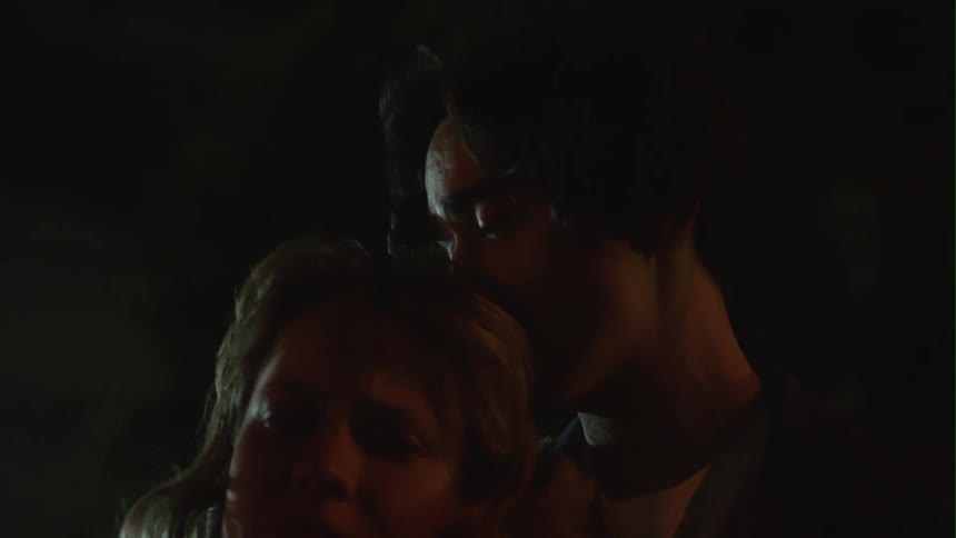 A man comforts a woman as they cry outside at night