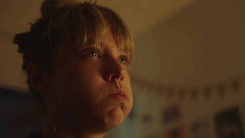 A bored looking young woman exhaling through her mouth