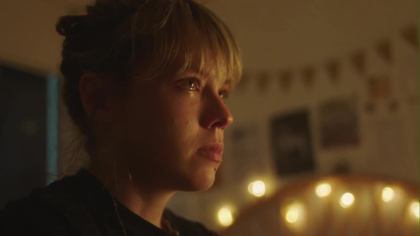 Young woman standing in her bedroom lashes out in anger while crying
