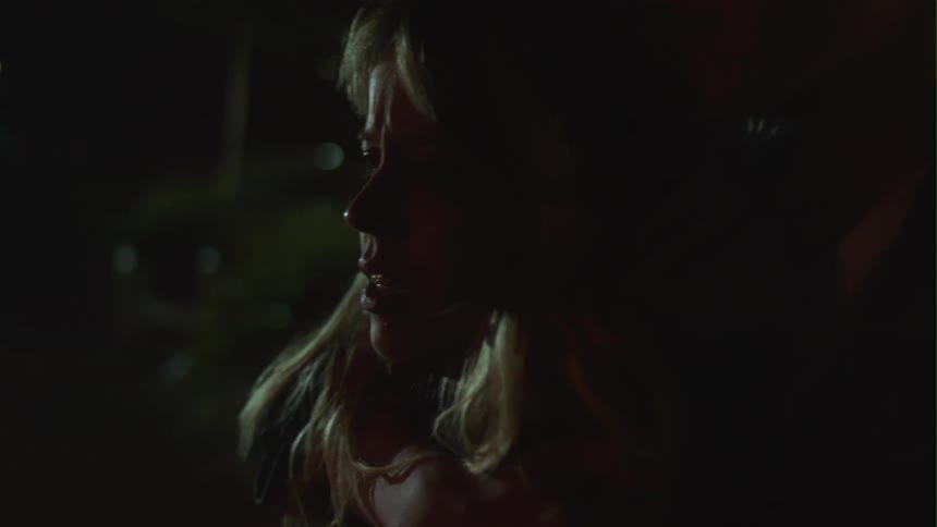 Man cuddles blonde woman weeping in the street at night