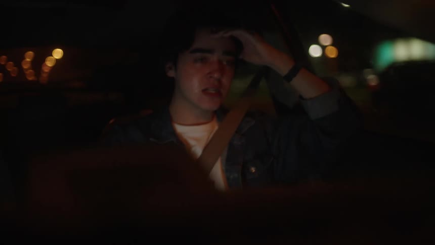 A person is a crying in the passenger seat of a car