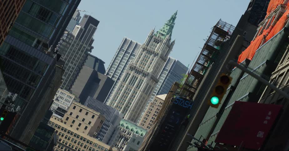 Ornate skyscrapers is viewable at end of street from intersection with a green light