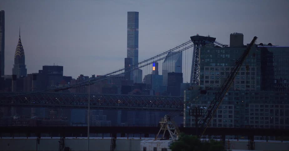 View of distant suspension bridge and high rise buildings in the city at dusk