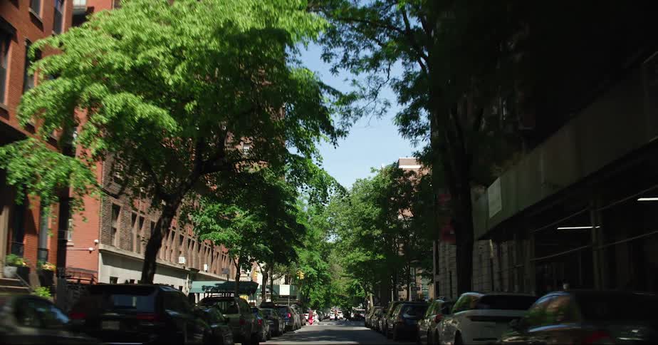 Vehicles line both sides of a city street in a neighborhood