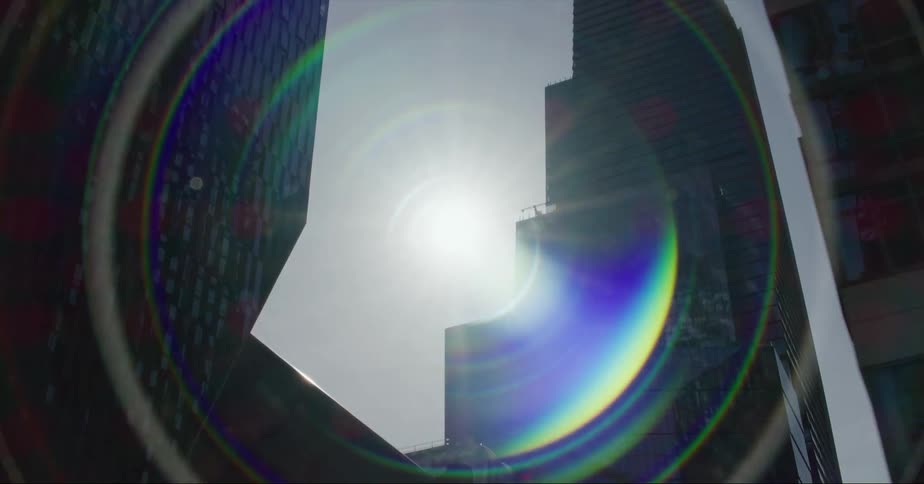 The sun is glaring between the buildings