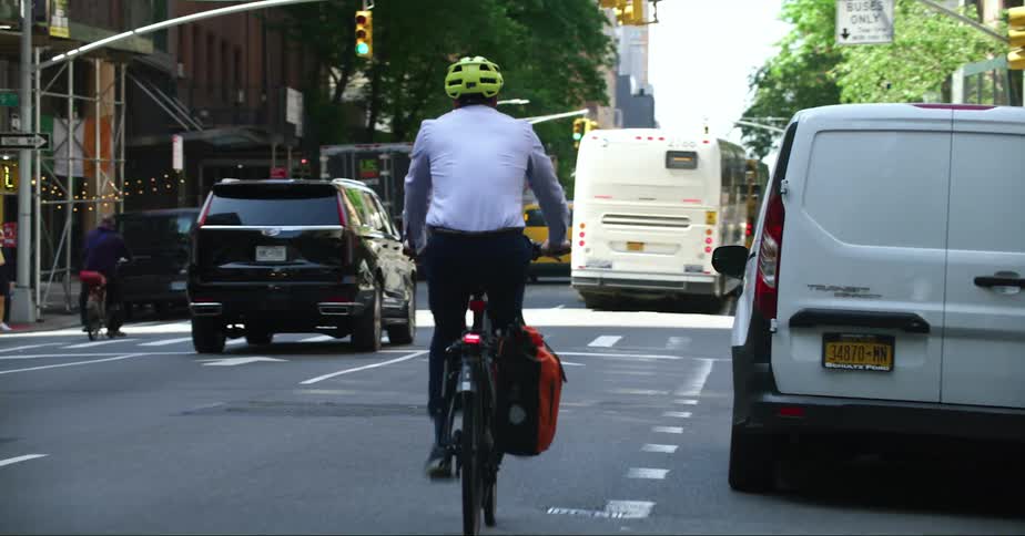 A person is riding a bike through city traffic during spring