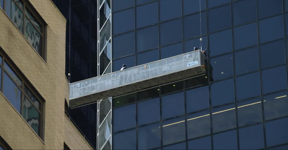 Window washers clean outside a tall skyscraper