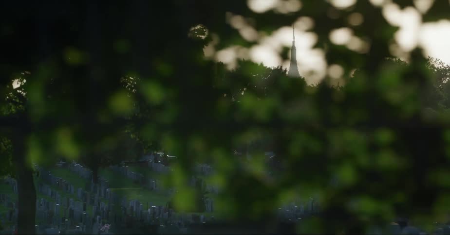 Tombstones on hill in cemetery at dusk