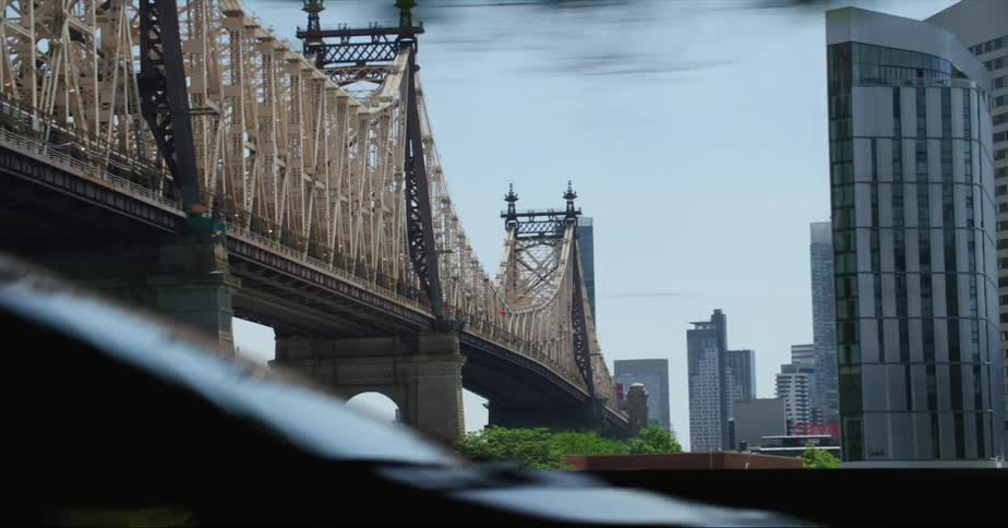 A bridge leads into downtown with tall buildings and skyscrapers on the skyline