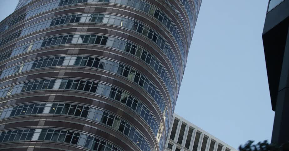 A skyscraper reflects off the mirrored windows of a nearby building
