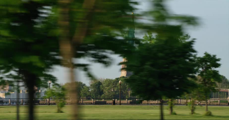 The statue of liberty with the skyline in the distance