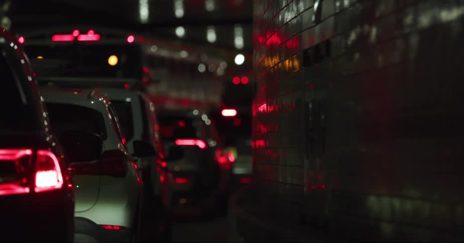 Cars are traveling inside a tunnel on a city street at night