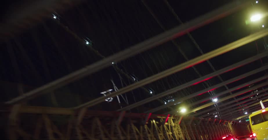 Cars are traveling on the brooklyn bridge in new york city at night