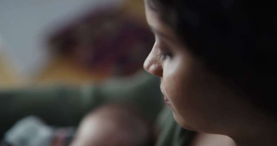 A woman sits and rocks her baby