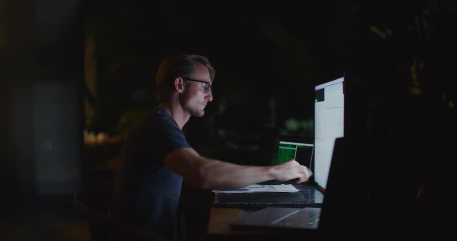 A man checks his phone while working at his desk