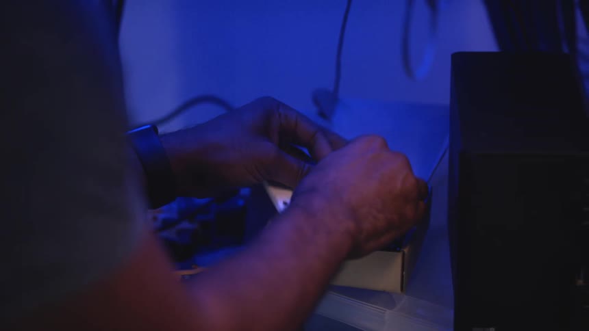 A person building a cable indoors
