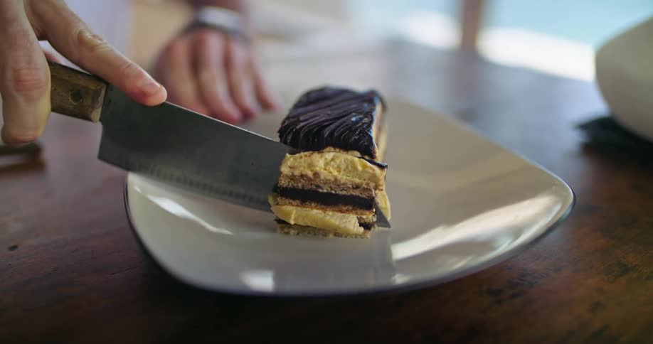 A person at home cuts a piece of cake