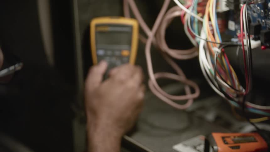 An electrician working on an electrical panel