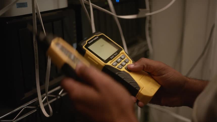 A man uses a voltage tester on electrical wires