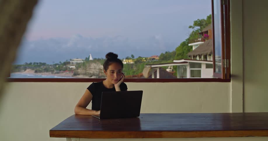 A woman is typing on her laptop at a desk