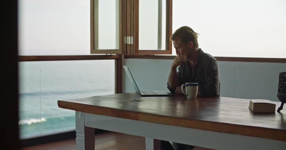 A man is looking at a laptop in his work office