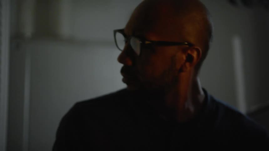Man looks around dim room then closes door behind him