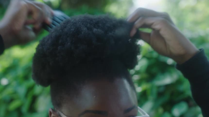 A woman combing her hair outdoors