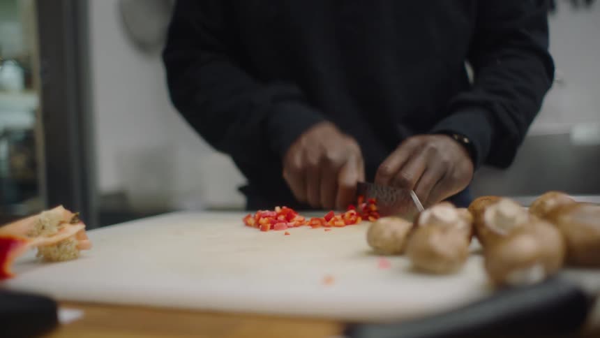 A man chopping up vegetables to cook