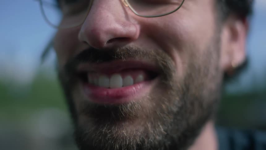 A man is smiling outside