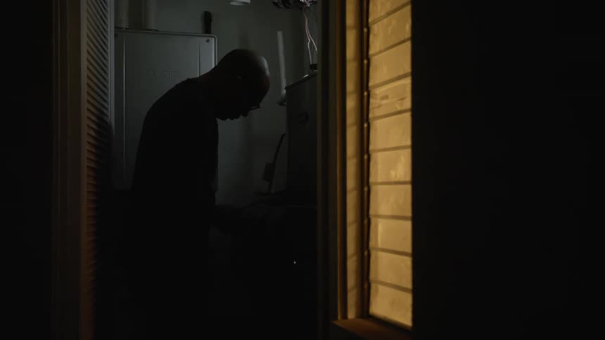 A man looking around in a house at night