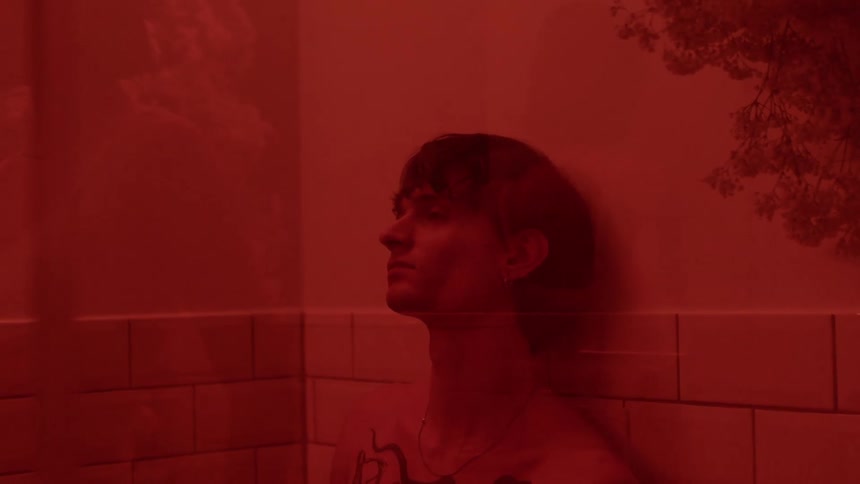 A man rests his hand against the wall in his shower