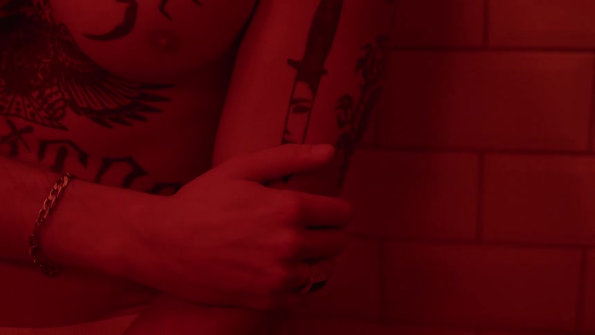 A man stands with his arms crossed in a shower