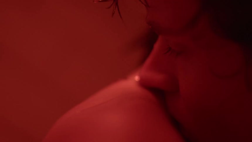 Close up of a man resting his head on a womans bare shoulder
