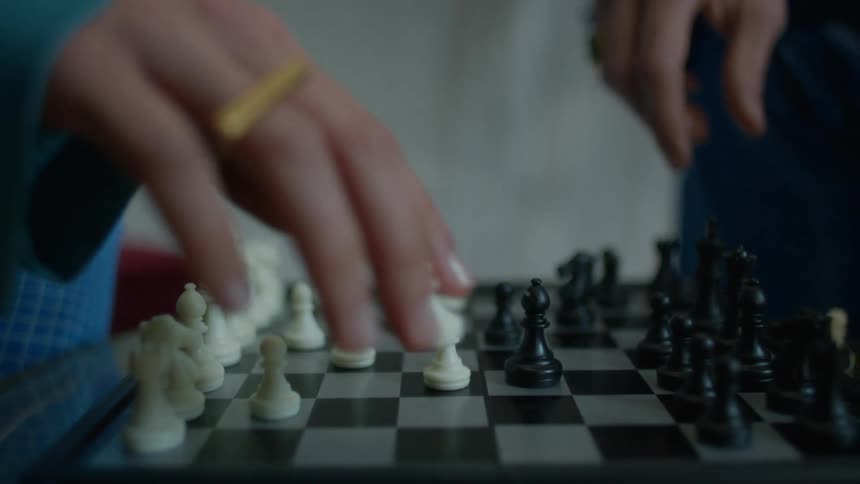 Fingers move a white pawn on the chessboard