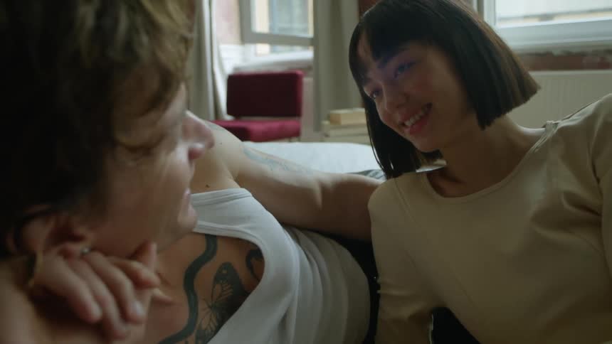 Couple smile and recline together in room
