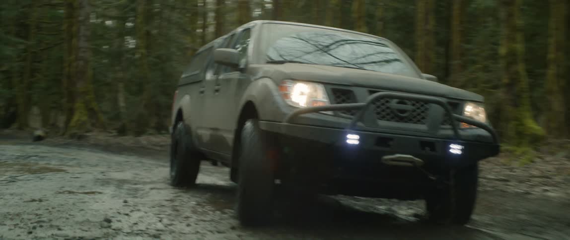 Black four wheel drive drives on muddy road in the forest